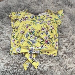 This is such a cute top it has types in the back this is a floral yellow top!!